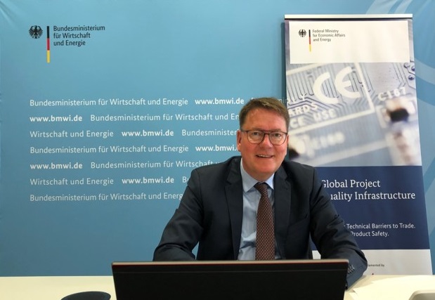 Dr. Zielke bei der Vorbereitungssitzung der Deutsch-Chinesischen Kommission zur Zusammenarbeit in der Normung. Er sitzt vor einem Laptop, hinter ihm sind BMWi und GPQI Logos.